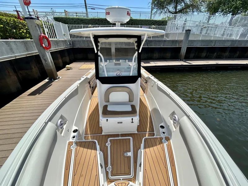Slide: The Image of 2013 Sailfish 270 CC boat docked, featuring spacious deck and modern design. - 9
