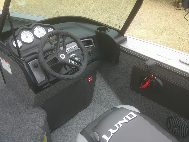 Slide: The Image of 2025 Lund 2075 Fisherman boat interior with steering wheel and dashboard controls. - 8