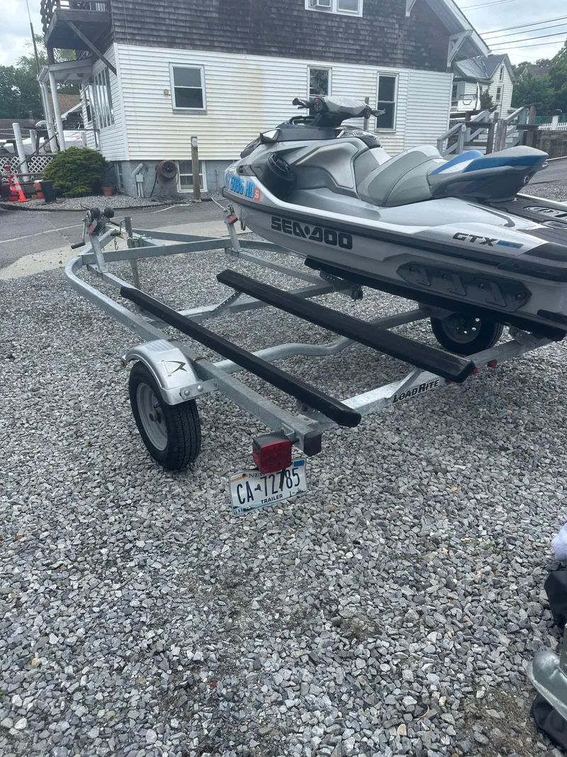 Slide: The Image of 2020 Sea-Doo GTX Limited 300 on trailer, parked on gravel near a house. - 15