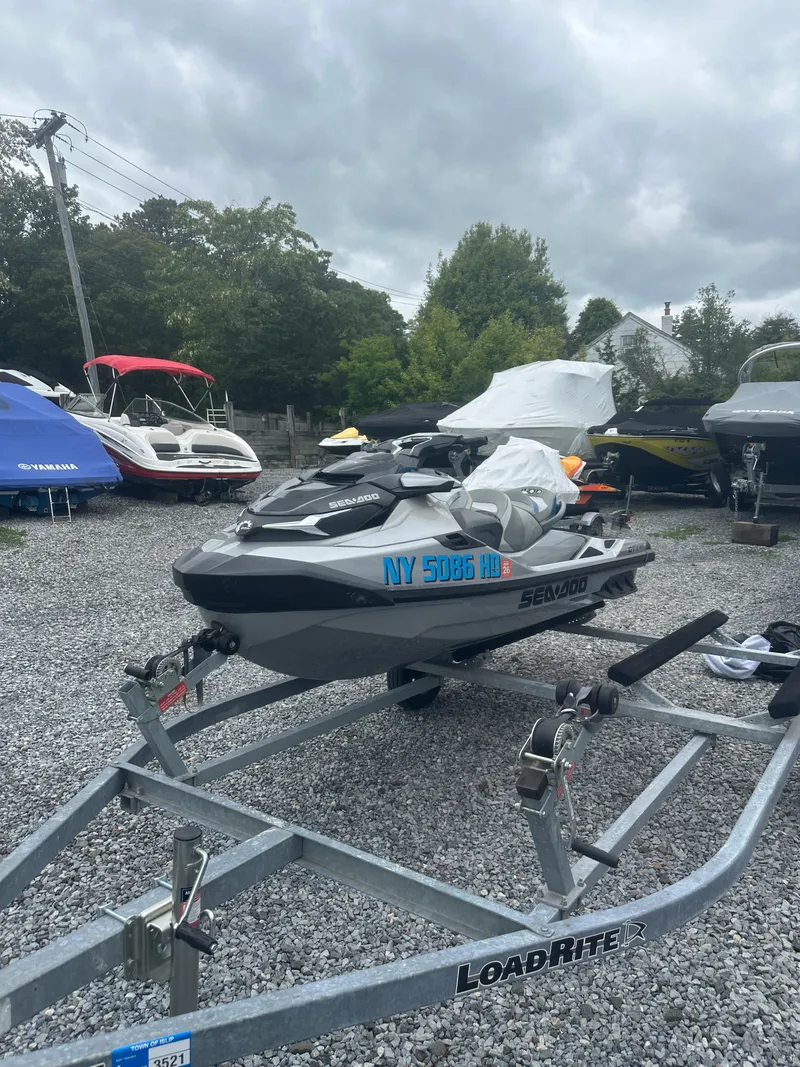 Slide: The Image of 2020 Sea-Doo GTX Limited 300 on trailer, parked on gravel lot with other boats. - 9