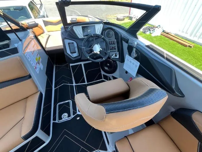 Slide: The Image of Interior of a 2025 Supreme S240 boat with modern dashboard and tan seating. - 12