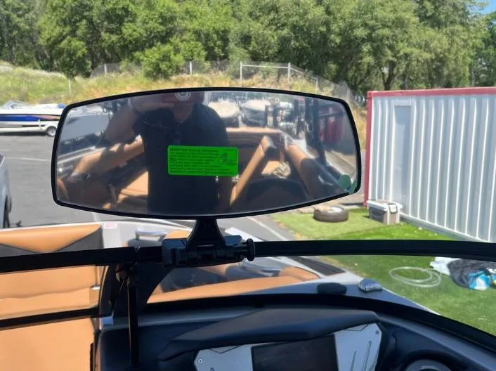 Slide: The Image of Rearview mirror view inside 2025 Supreme S240 boat, showing interior and outdoor setting. - 19