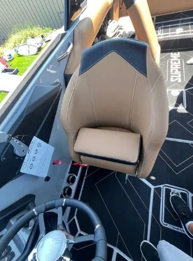Slide: The Image of 2025 Supreme S240 boat interior with tan seating and modern dashboard design. - 20