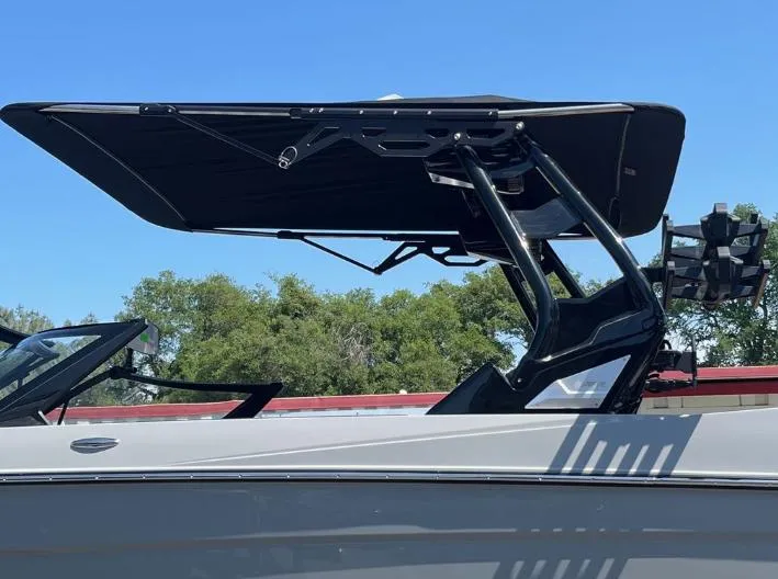 Slide: The Image of 2025 Supreme S240 boat with sleek black canopy against a clear blue sky. - 29