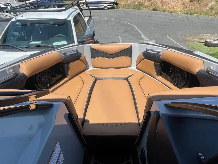 Slide: The Image of 2025 Supreme S240 boat interior with tan and black seating, featuring built-in speakers. - 31