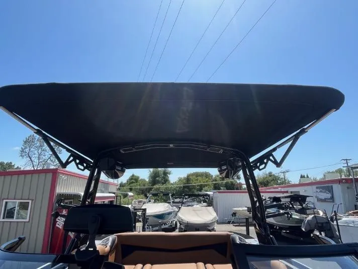 Slide: The Image of 2025 Supreme S240 boat with canopy, parked in a marina under clear blue sky. - 35