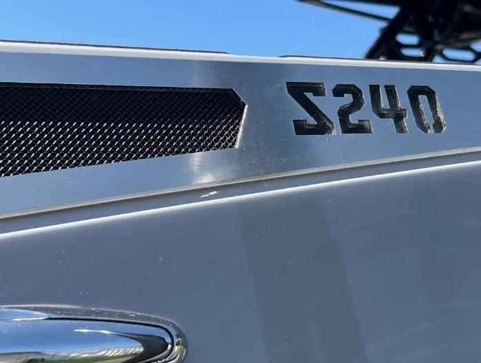 Slide: The Image of Close-up of 2025 Supreme S240 model emblem on a sleek silver surface. - 42