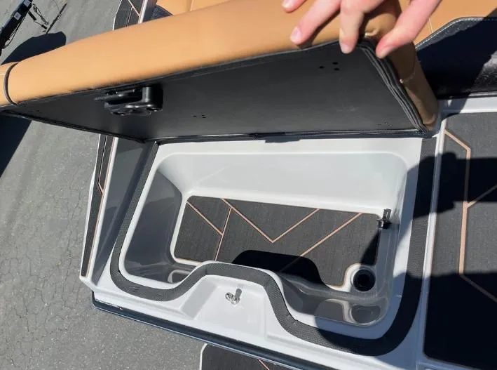 Slide: The Image of Open storage compartment in a 2025 Supreme S240 boat with tan seating. - 5