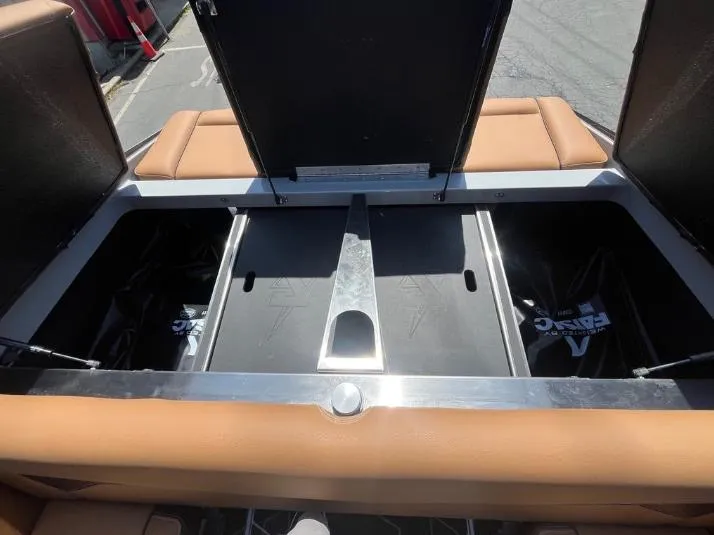 Slide: The Image of Open storage compartments in a 2025 Supreme S240 boat with tan seating. - 8