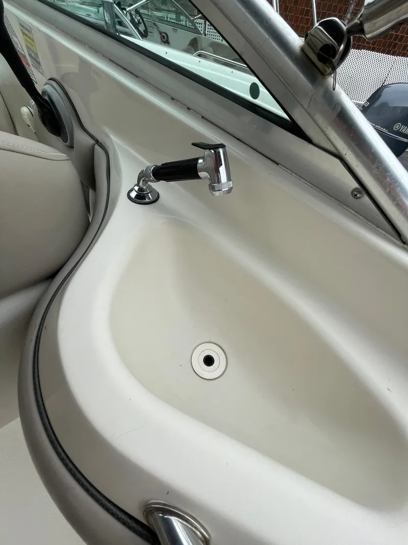 Slide: The Image of 2004 Sea Ray 220 Sundeck boat sink with faucet, white interior. - 11