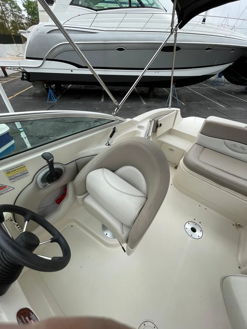 Slide: The Image of 2004 Sea Ray 220 Sundeck interior with steering wheel and seating. - 15