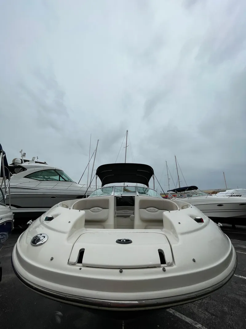 Slide: The Image of 2004 Sea Ray 220 Sundeck boat docked under cloudy skies. - 16