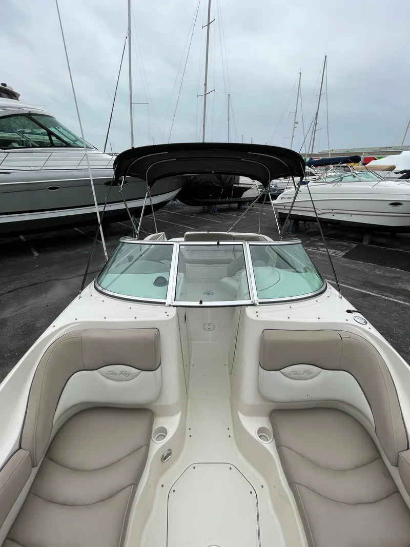 Slide: The Image of 2004 Sea Ray 220 Sundeck boat with spacious seating, docked among other vessels. - 21