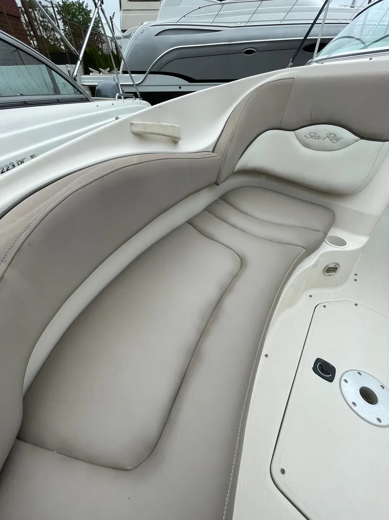 Slide: The Image of 2004 Sea Ray 220 Sundeck interior seating, featuring beige upholstery and sleek design. - 22
