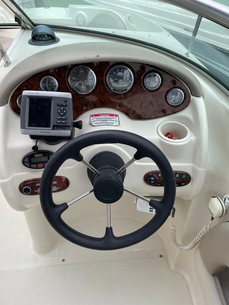 Slide: The Image of Steering wheel and dashboard of a 2004 Sea Ray 220 Sundeck boat. - 26