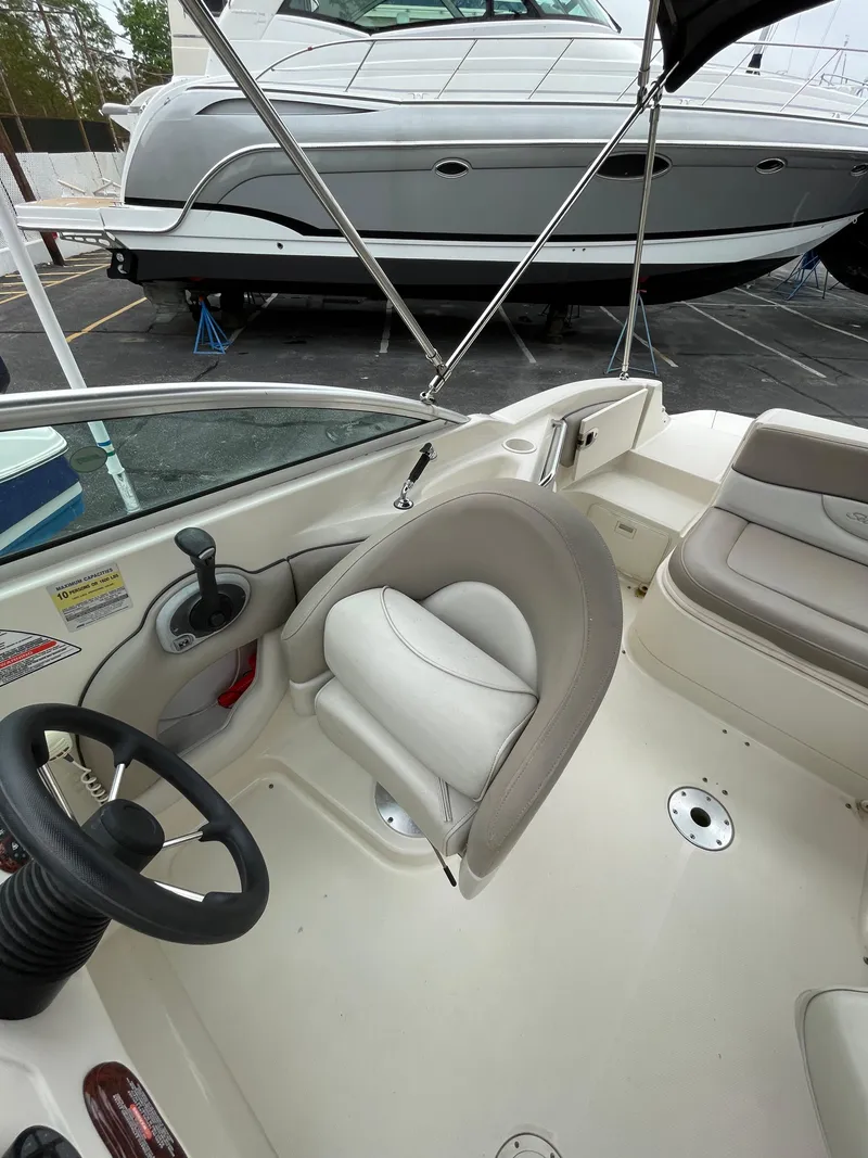 Slide: The Image of 2004 Sea Ray 220 Sundeck interior with steering wheel and seating. - 7