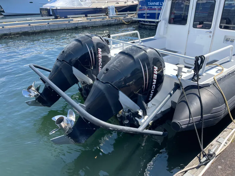 Slide: The Image of Twin Mercury outboard engines on a 2007 Titan T-300 boat docked at a marina. - 14