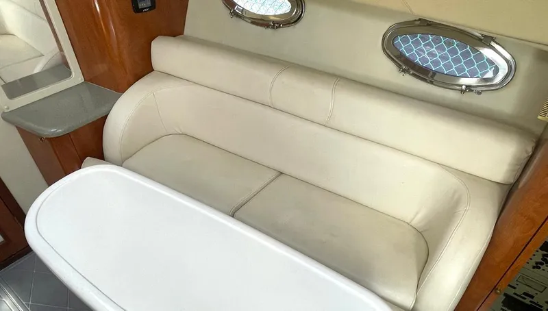 Slide: The Image of Interior of 2002 Fountain 38 Express Cruiser with beige seating and oval windows. - 12