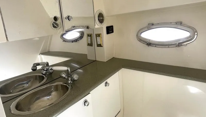 Slide: The Image of 2002 Fountain 38 Express Cruiser bathroom with dual sinks and oval porthole windows. - 14
