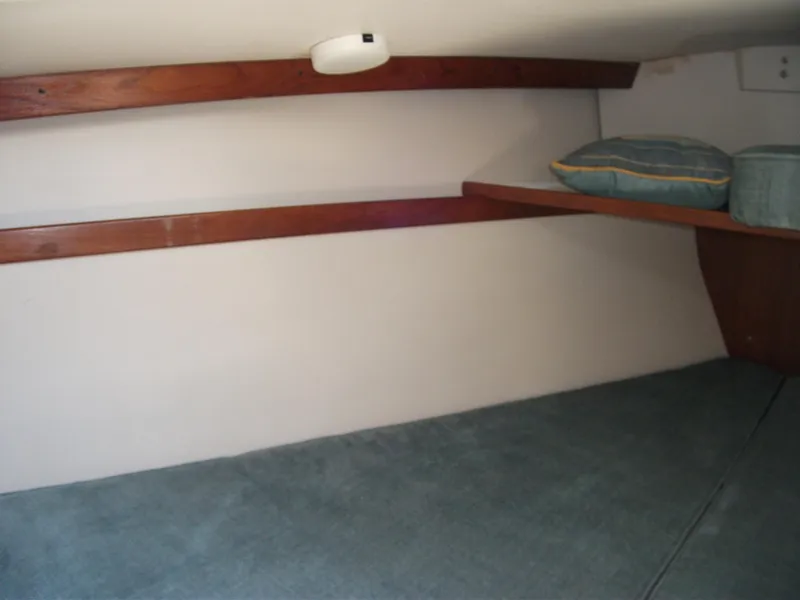Slide: The Image of Interior cabin of a 1992 Catalina 30 MkII sailboat with wooden shelves and cushions. - 16