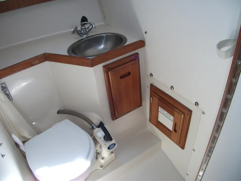 Slide: The Image of 1992 Catalina 30 MkII boat bathroom with sink, toilet, and wooden storage cabinets. - 20