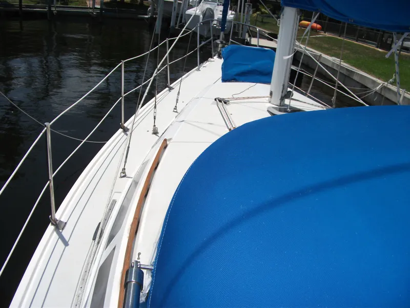 Slide: The Image of 1992 Catalina 30 MkII sailboat deck with blue covers, docked by the water. - 7