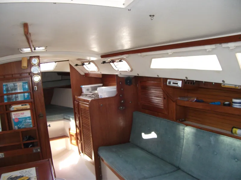 Slide: The Image of Interior of 1992 Catalina 30 MkII sailboat with wooden cabinetry and blue seating. - 8