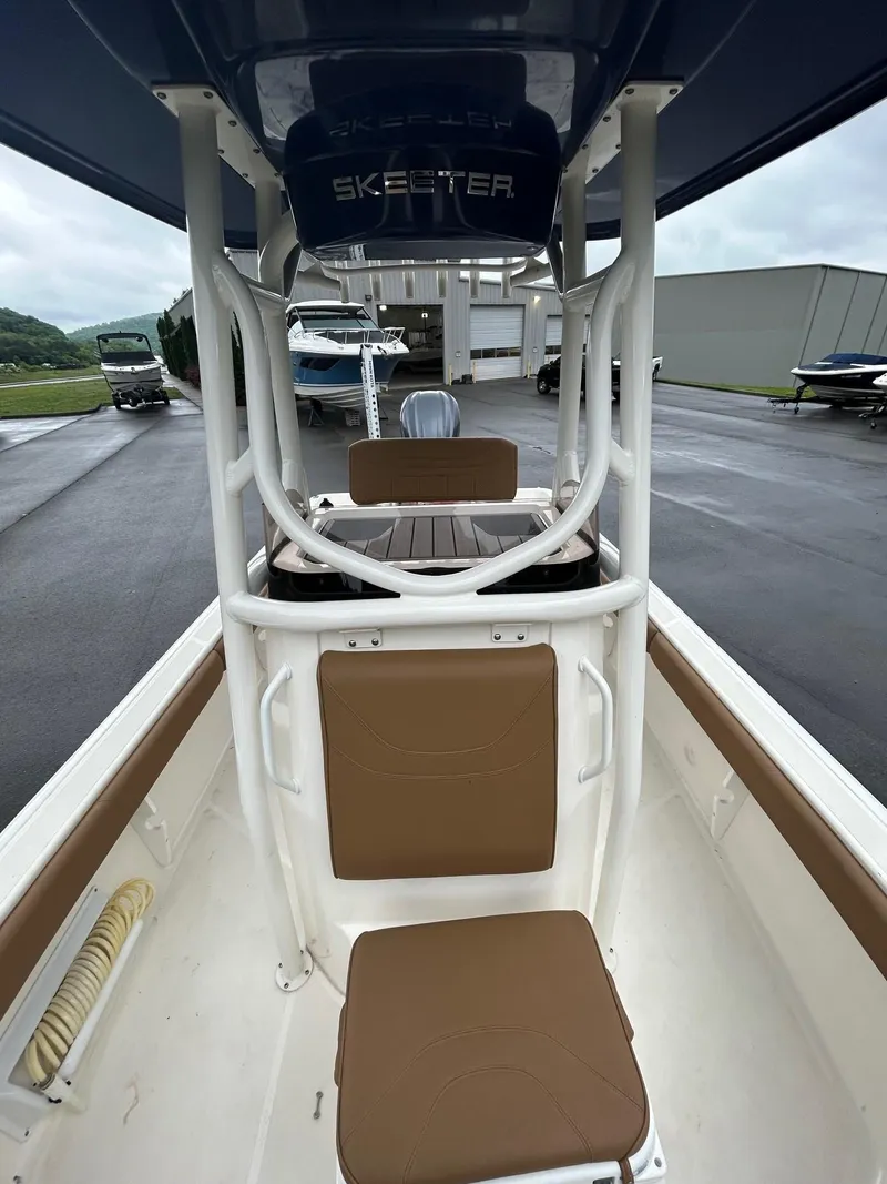 Slide: The Image of 2023 Skeeter SX 2250 boat interior with seating and console, parked outdoors. - 5