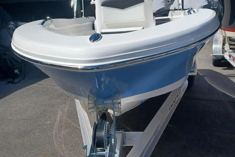 Slide: The Image of 2025 Robalo R160 Center Console boat on trailer, front view, blue and white design. - 3