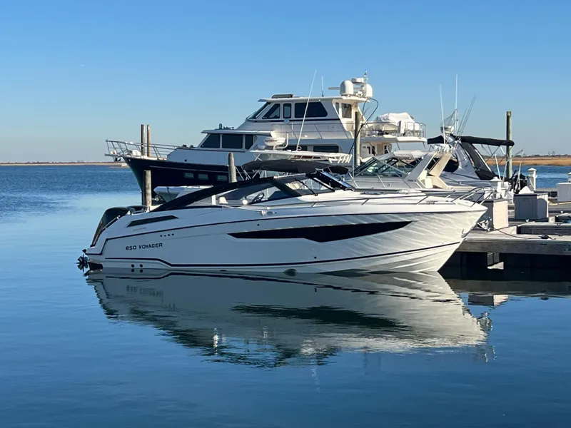 The Image of 2023 Hussar 850 boat docked at marina, reflecting on calm water. - 0