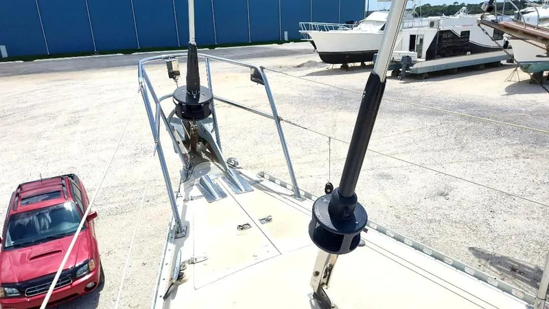 Slide: The Image of Bow view of 1985 Tayana Vancouver 42 sailboat in a boatyard, with a red SUV nearby. - 13