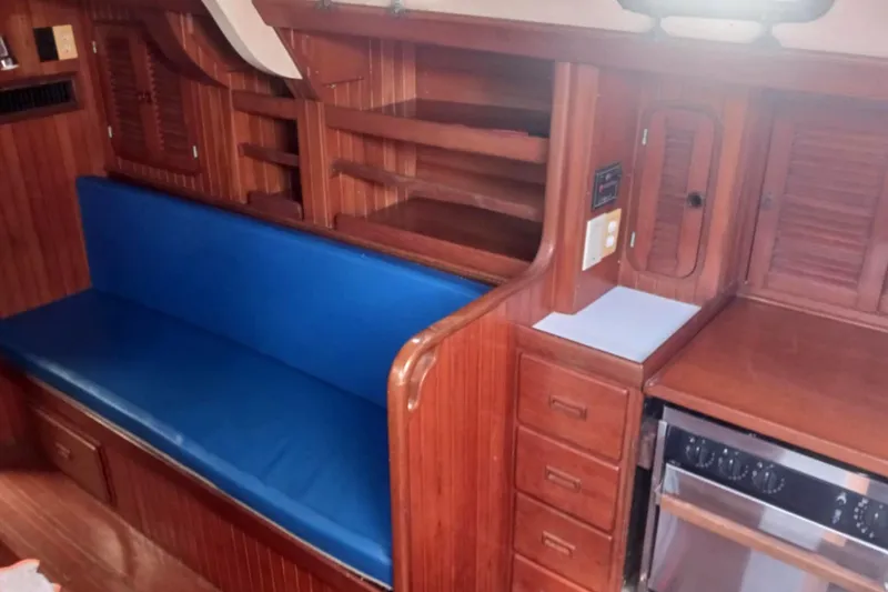 Slide: The Image of Interior of 1985 Tayana Vancover 42 yacht with blue seating and wooden cabinetry. - 19