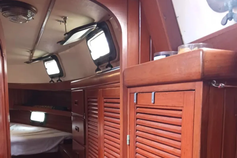 Slide: The Image of Interior of 1985 Tayana Vancover 42 sailboat with wooden cabinetry and portholes. - 21