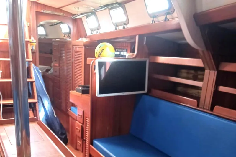 Slide: The Image of Interior of 1985 Tayana Vancover 42 yacht with blue seating and wooden cabinetry. - 22
