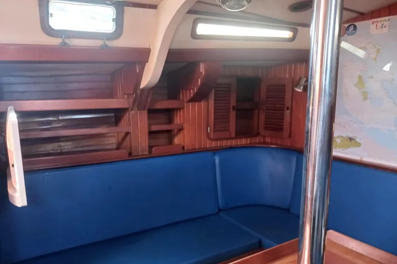 Slide: The Image of Interior of 1985 Tayana Vancover 42 sailboat with blue seating and wooden cabinetry. - 23