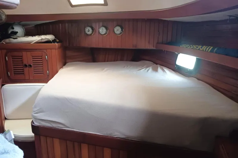 Slide: The Image of Cozy cabin interior of 1985 Tayana Vancover 42 sailboat with wooden paneling and bed. - 24