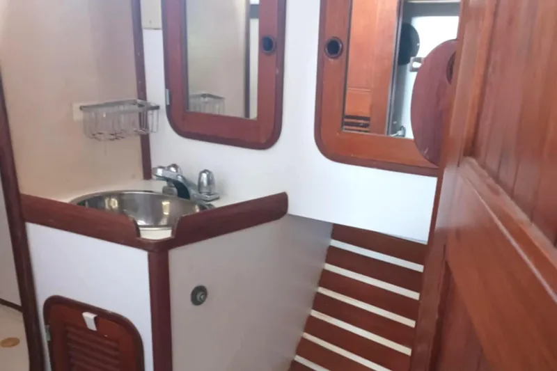 Slide: The Image of Interior of 1985 Tayana Vancover 42 sailboat bathroom with wooden accents and sink. - 27
