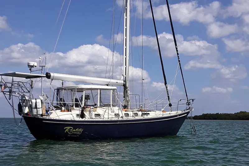 Slide: The Image of 1985 Tayana Vancover 42 sailboat on calm waters under a partly cloudy sky. - 3