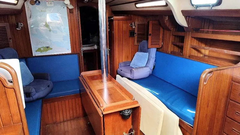 Slide: The Image of Interior of 1985 Tayana Vancover 42 sailboat with blue seating and wooden paneling. - 33