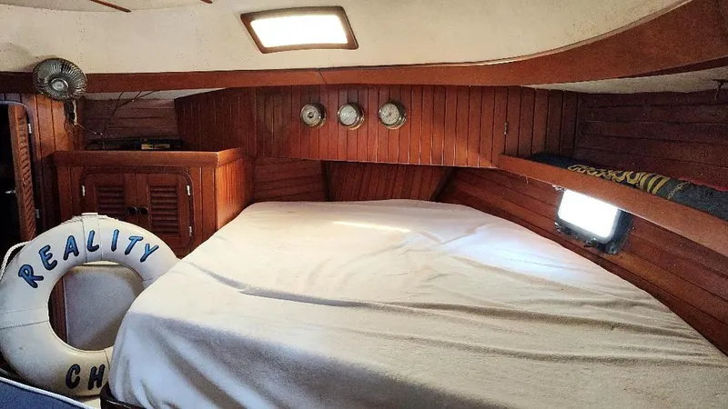 Slide: The Image of Cozy cabin interior of 1985 Tayana Vancover 42 sailboat with wooden paneling and portholes. - 36