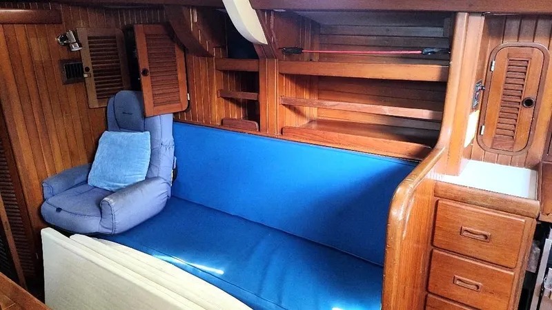 Slide: The Image of Interior of 1985 Tayana Vancover 42 yacht with blue seating and wooden cabinetry. - 39
