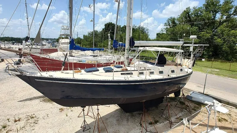 Slide: The Image of 1985 Tayana Vancover 42 sailboat on stands in a boatyard under a clear sky. - 7