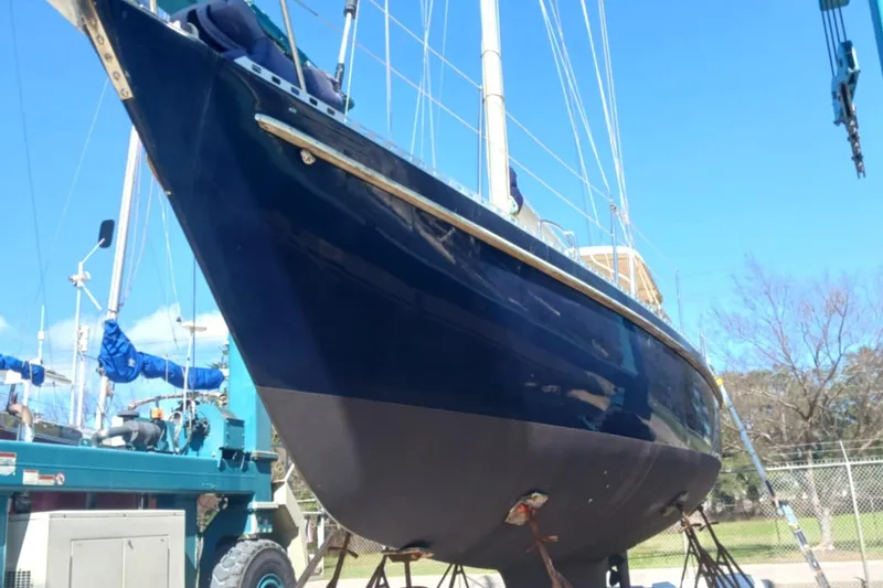 Slide: The Image of 1985 Tayana Vancover 42 sailboat on dry dock, blue hull, clear sky background. - 8