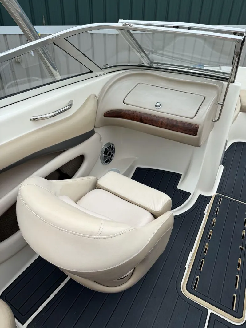 Slide: The Image of 2006 Glastron GX 235 boat interior with beige seating and sleek dashboard design. - 10