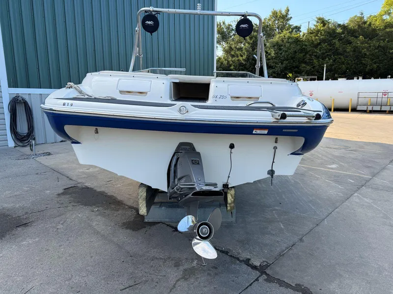 Slide: The Image of 2006 Glastron GX 235 boat, rear view, parked on concrete near a building. - 3