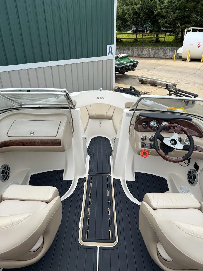 Slide: The Image of 2006 Glastron GX 235 boat interior with beige seating and sleek dashboard design. - 7