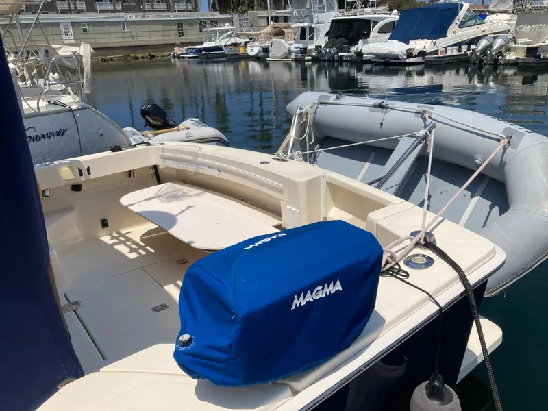 Slide: The Image of 2004 Mainship Pilot 34 boat docked, featuring a covered Magma grill on deck. - 12