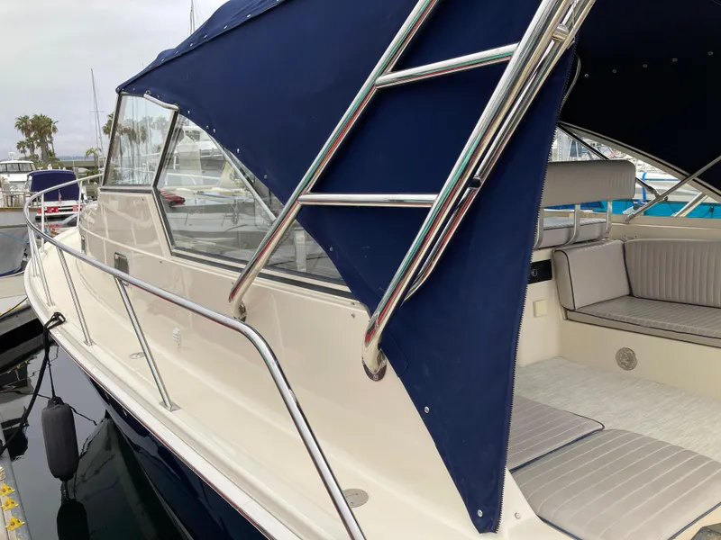 Slide: The Image of 2004 Mainship Pilot 34 boat with blue canopy and stainless steel ladder. - 13
