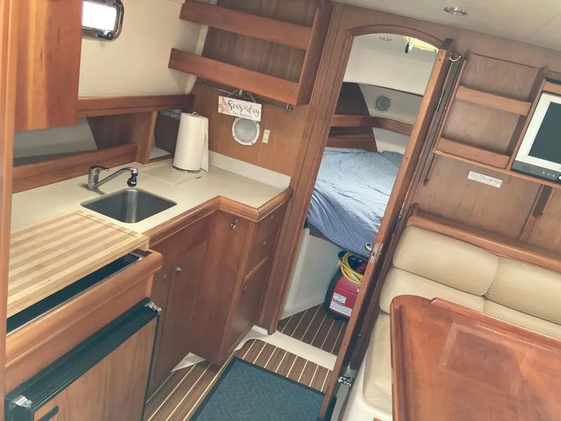 Slide: The Image of 2004 Mainship Pilot 34 interior with kitchenette, seating, and sleeping area. - 31