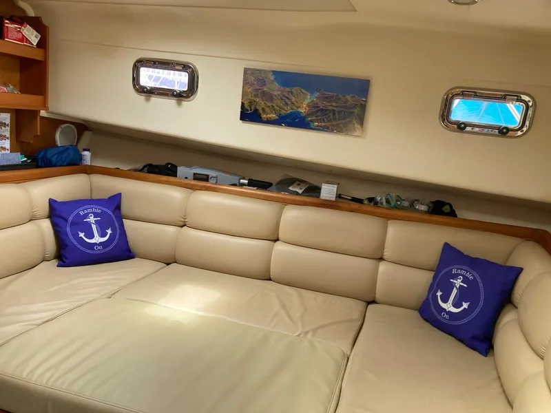 Slide: The Image of Interior of 2004 Mainship Pilot 34 with beige seating and nautical-themed pillows. - 36